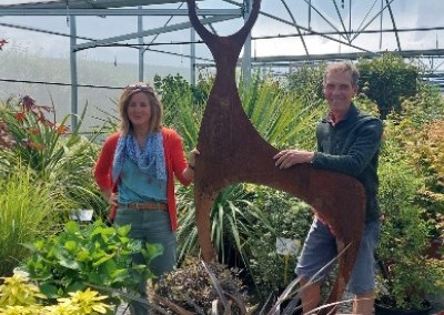 man and woman in greenhouse garden holding model deer
