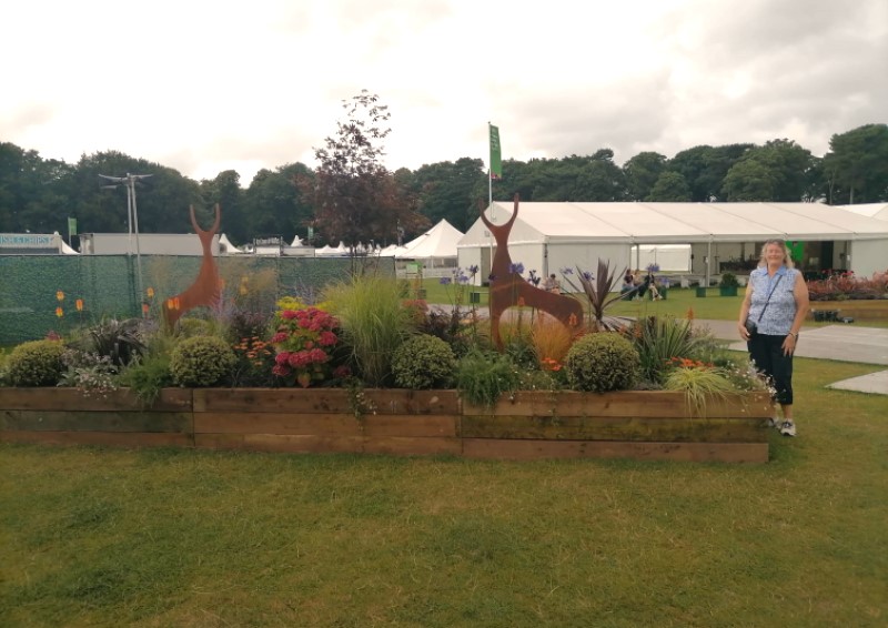 model deer in flower and plant exhibit in front of white marquee